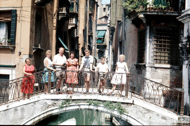 A family poses for a picture on a bridge in Venice.