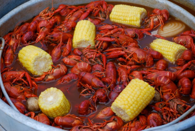 A pot of crawfish and corn on the cob waits to be eaten.