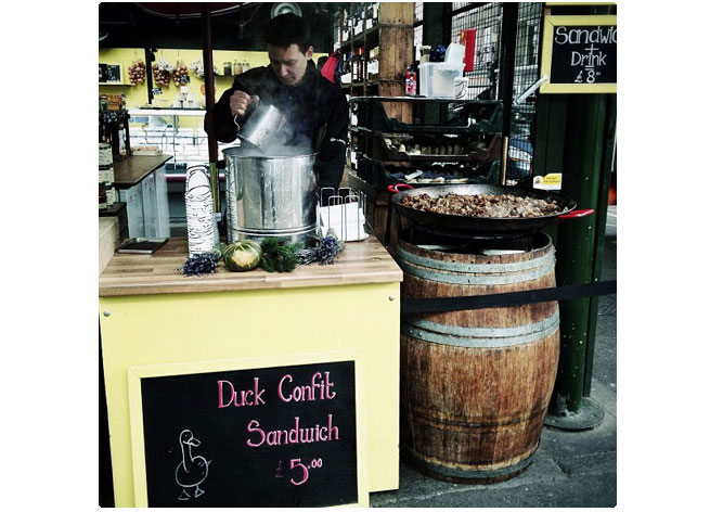 A food vendor sells duck confit sandwiches in London, England. You can eat in London for less than $25 a meal. Check out these ideas from RoamRight.