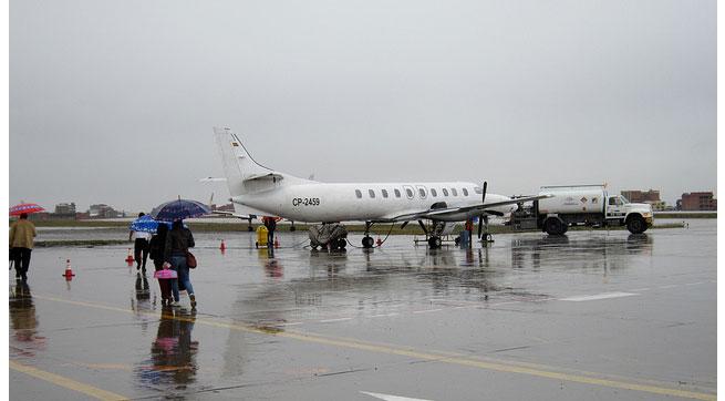 An airplane sits on the tarmac during a rainstorm. Air travelers have different methods for keeping their sanity on an airplane. Here are RoamRight's tips.