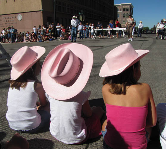 Three girls enjoy watching an event at the Cheyenne Frontier Days Rodeo.