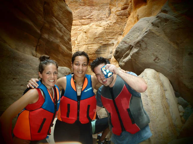 A group of three friends travel together and pose for pictures.